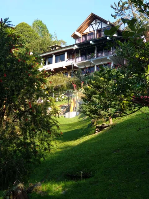 El chalet en la colina, rodeado de jardín y árboles