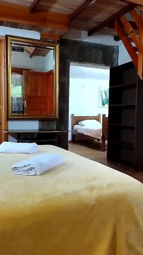 Habitación con espejo dorado y cama matrimonial