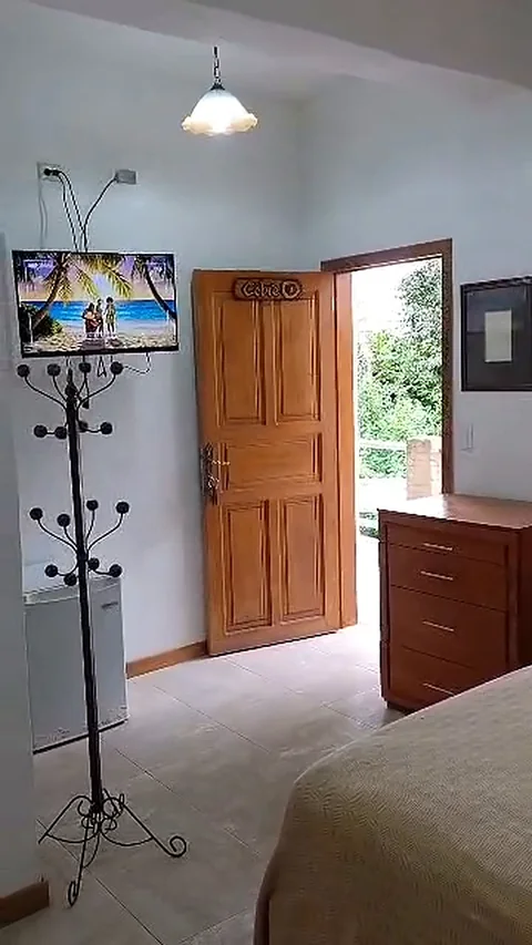 Habitación con perchero, puerta de madera y televisor