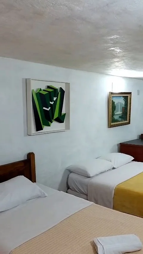 Habitación con dos camas y cuadros en la pared