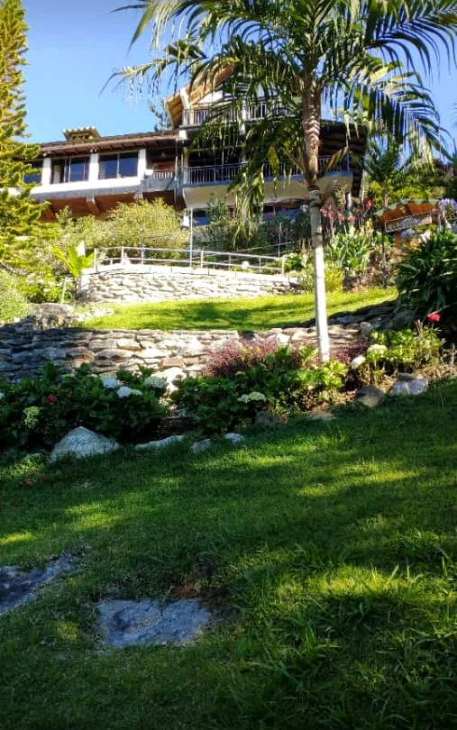 Jardín con grama y plantas frente a la casa