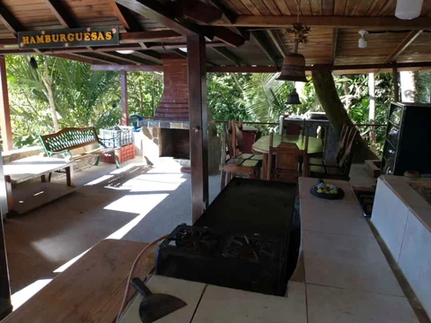 Salón parrillero techado con mesas de madera